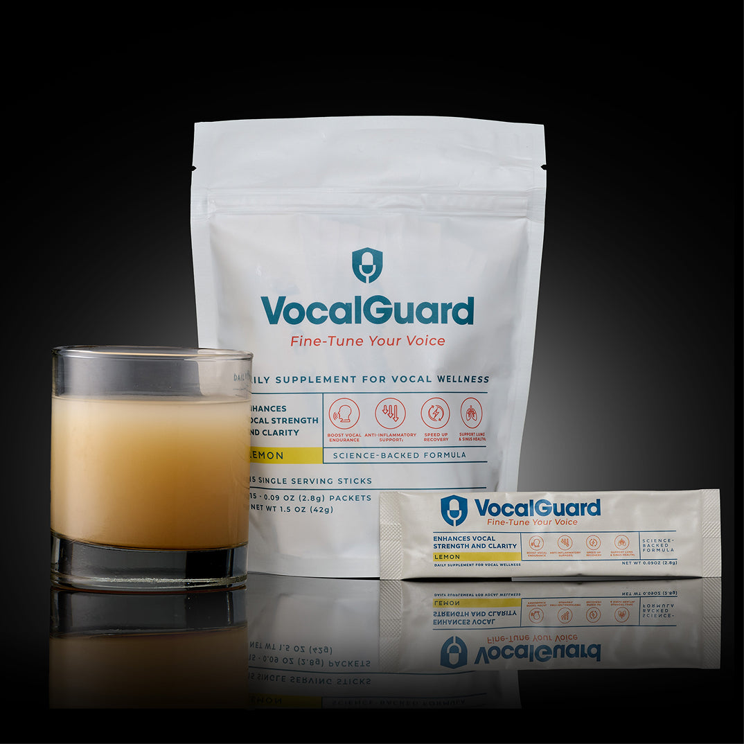VocalGuard — powder pouch with a single-serving stick and a mixed glass of the drink, dark studio.