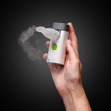 VocalMist Portable Nebulizer — device held in hand against a dark studio background.