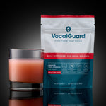 VocalGuard Fruit Blend powder pouch (30-day supply) with mixed glass, studio shot