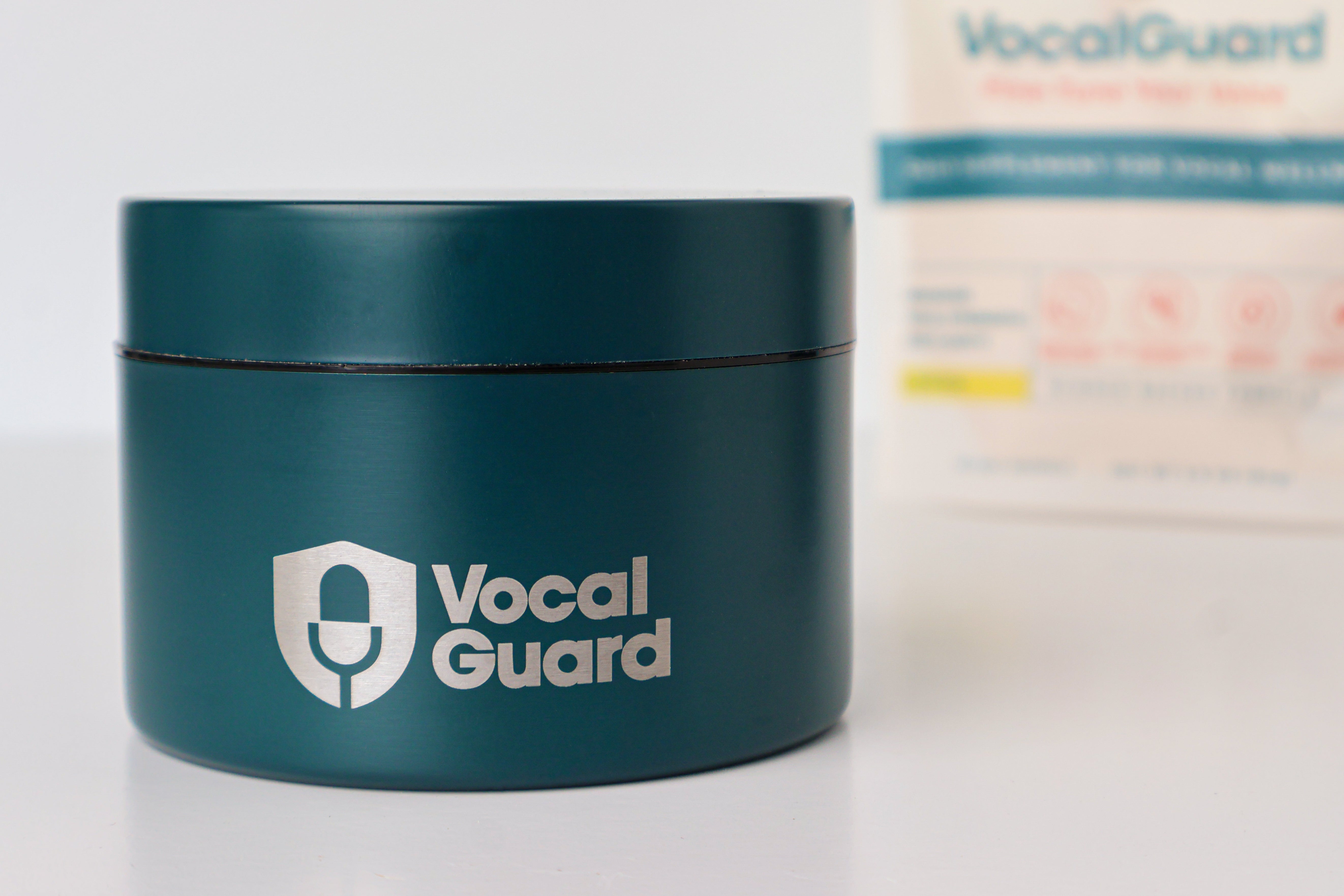 VocalGuard Vault — closed container on a white table with the VocalGuard pouch behind.