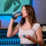 VocalGuard Glass Bottle — a singer drinking from the bottle in a recording studio.