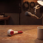 Breather Voice respiratory trainer on a broadcast desk beneath a microphone and lamp.