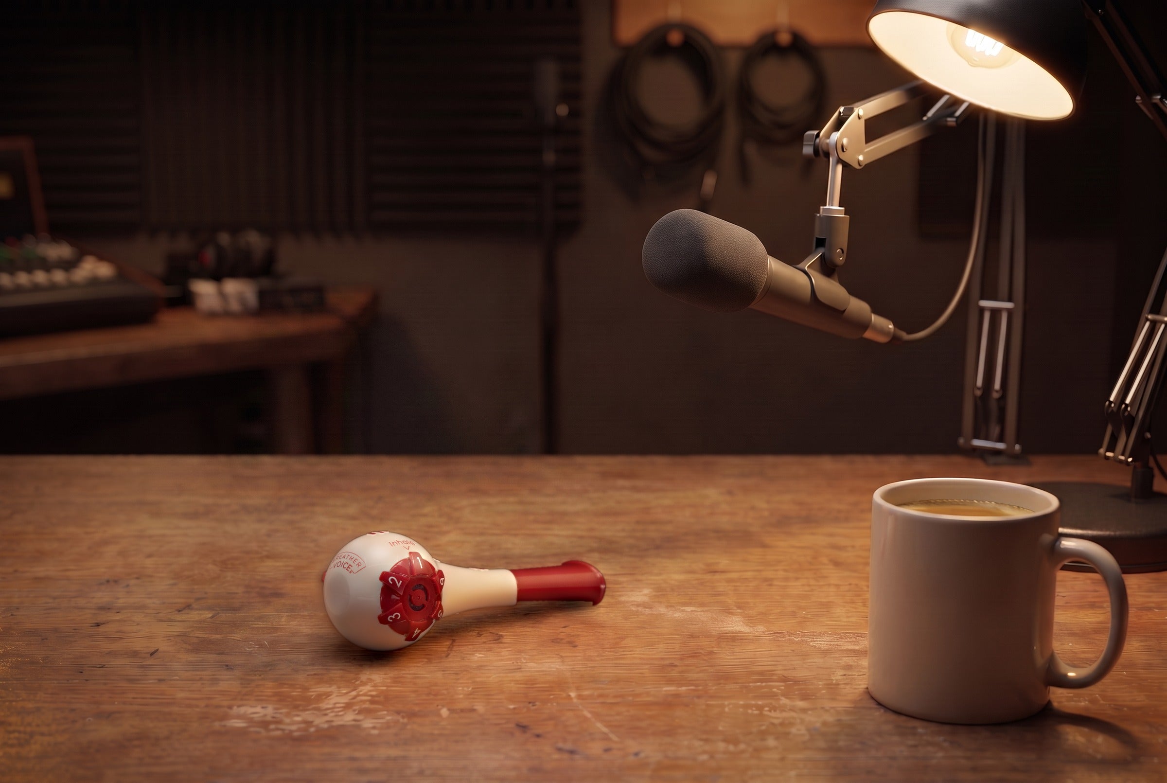Breather Voice respiratory trainer on a broadcast desk beneath a microphone and lamp.