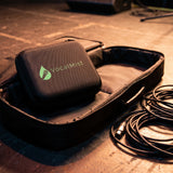 VocalMist carrying case on an open gig bag backstage with coiled XLR cables.