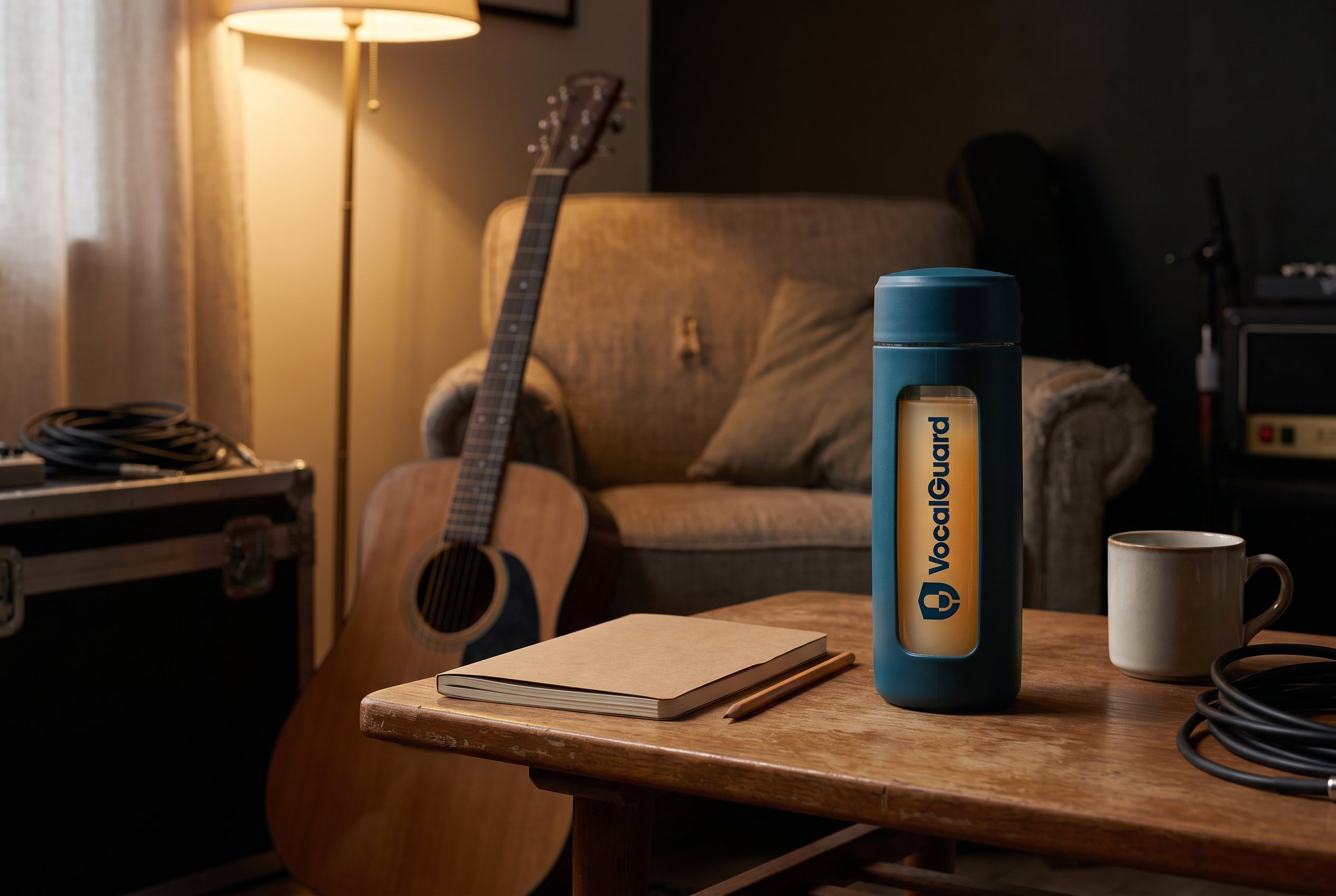 VocalGuard glass bottle on a songwriting coffee table next to an acoustic guitar.