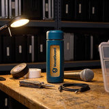 VocalGuard glass bottle on a backline workbench under a work light.