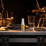 Vocal Eze Throat Spray standing on a road case backstage with a coiled cable.