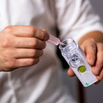 VocalMist Hydration Formula — squeezing a saline vial into the nebulizer's medication cup.