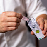 VocalMist Hydration Formula — squeezing a saline vial into the nebulizer's medication cup.