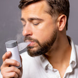 VocalMist Hydration Formula — a singer inhaling mist from the VocalMist nebulizer.