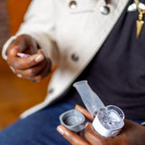 VocalMist Hydration Formula — opening a saline vial over the nebulizer's mouthpiece and cap.