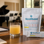 VocalGuard lemon vocal-wellness supplement pouch and single-serving stick on a rehearsal-room table.