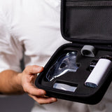 VocalMist Carrying Case — open case held in hands, showing the nebulizer and accessories in the foam insert.