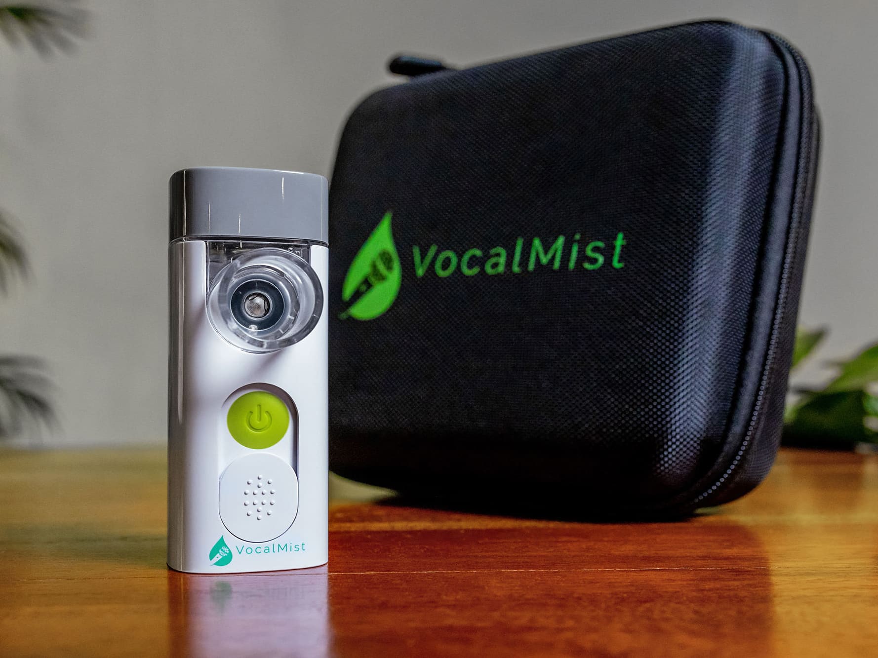 VocalMist Carrying Case — nebulizer standing beside the closed case on a wooden table.