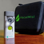 VocalMist Carrying Case — nebulizer standing beside the closed case on a wooden table.
