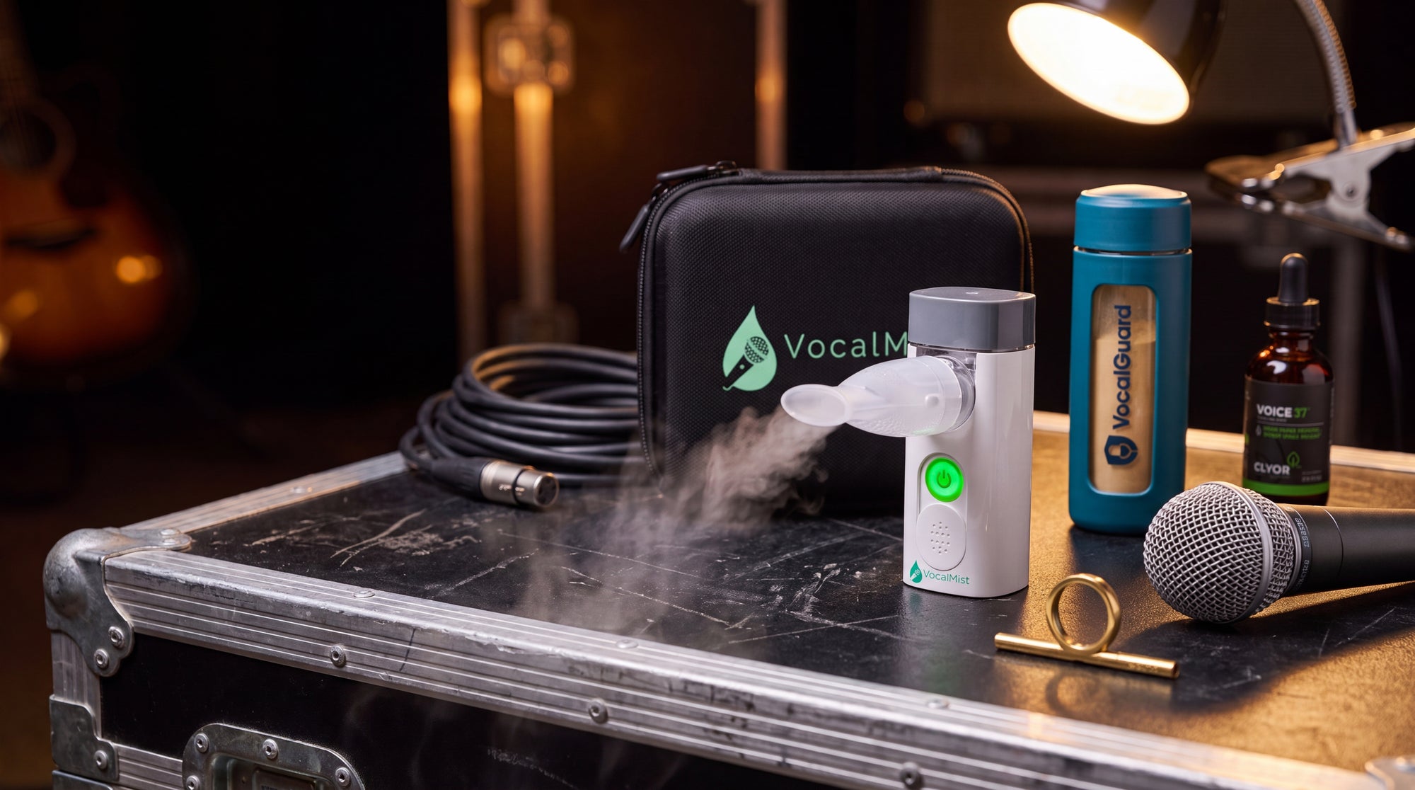 VocalMist portable nebulizer misting on a road case beside VocalGuard, VOICE37, and a microphone, backstage